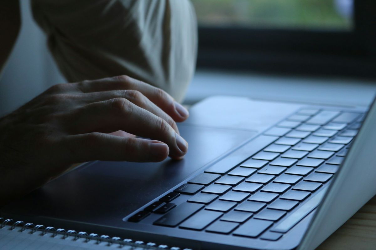 Person soeker jobber paa laptop ved vinduet
